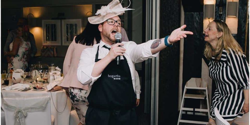 singing waiter wearing a hat
