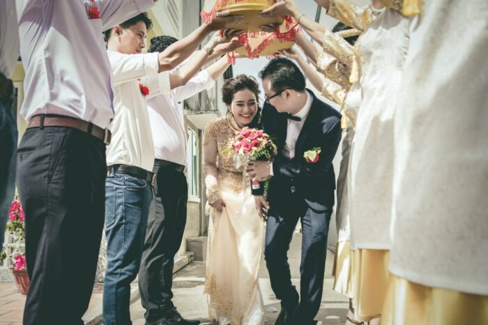 Asian couple walk under confetti for blog about wedding day timelines