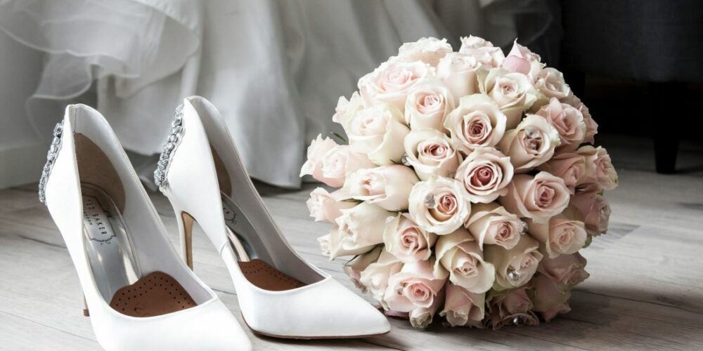 Brides bouquet and heels sit waiting for wedding day on blog about wedding day timelines.