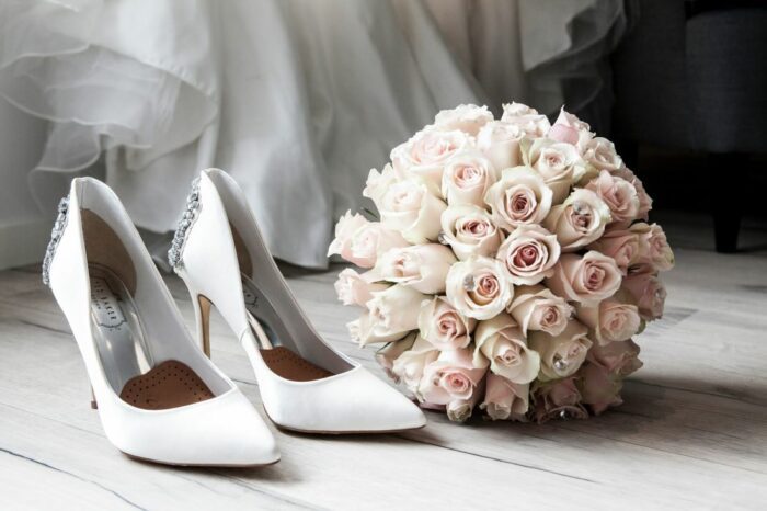 Brides bouquet and heels sit waiting for wedding day on blog about wedding day timelines.